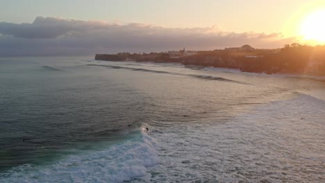 Surfista-Atrapando-Grandes-Olas-En-La-Costa-De-Indonesia-Bali-Uluwatu-En-La-Pintoresca-Puesta-De-Sol-Colorida