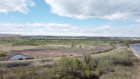 Carril-Bici-En-El-Parque-De-La-Ciudad-Junto-Con-El-Río-Y-El-Campo-De-Golf-Y-Las-Colinas-En-El-Fondo