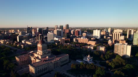 Toma-Aérea-De-La-Hora-Dorada-Del-Horizonte-De-Winnipeg-Con-Edificio-Legislativo