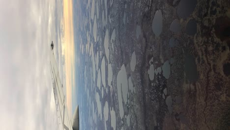 Vertical-shot-through-airplane-window-of-small-lakes-Wapusk-National-Park-Churchill-Manitoba-Northern-Canada