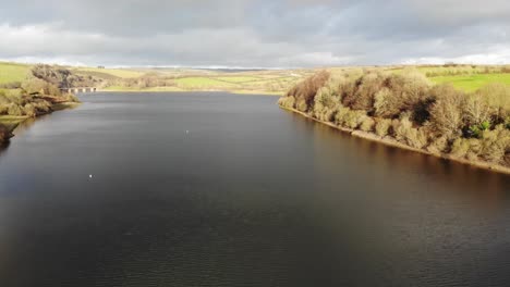Aerial-Rising-Over-Calm-Wimbleball-Lake-On-Exmoor-In-Somerset