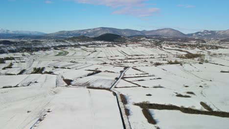 Aerial-panoramic-view-of-a-rural-landscape-with-fields-coved-with-snow-in-a-beautiful-sunny-winter-day,-Dalmatian,-Croatia