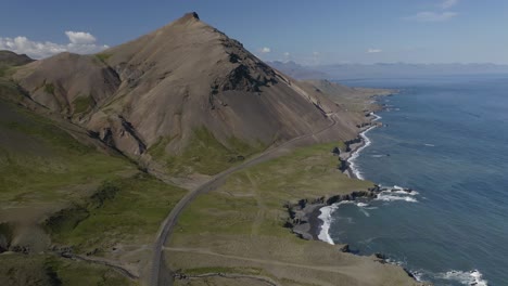 Aerial-forward-shot-of-volcanic-landscape-and-coastline-of-Iceland-during-sunlight---Hvalnesskriður,-Krossanesfjall