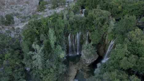 Descriptive-panning-drone-video-with-zenith-and-in-reverse-over-the-Manojlovac-waterfall-on-the-Krka-river-in-Croatia-ending-the-horizon-on-the-mountain