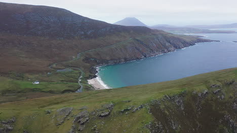 Revealing-cinematic-drone-shot-of-a-small-bay-and-Keem-beach,-Ireland-on-the-Wild-Atlantic-Way