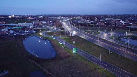 Aerial-view-Mersey-gateway-illuminated-freeway-bridge-overpass-lanes-early-morning-sunrise-fast-reverse