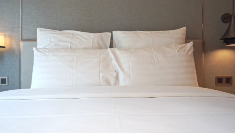 Pan-left-to-right-across-the-pillows-of-a-resort-hotel-bed