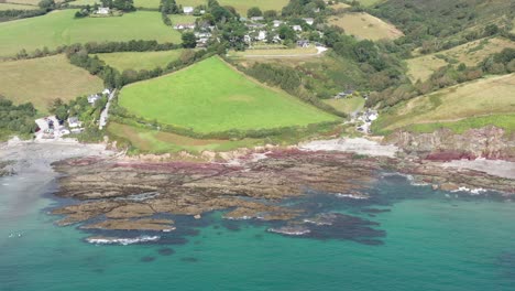 Wide-aerial-establishing-shot-of-Talland-Bay-on-the-Cornish-coast,-with-dramatic-surrounding-scenery