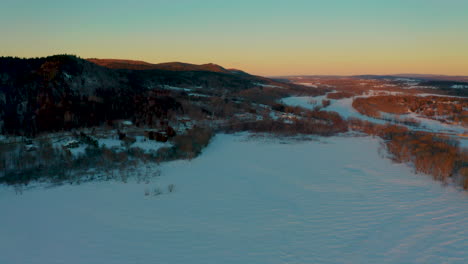 Aerial-drone-view-of-a-scenic-snowy-countryside-at-dusk