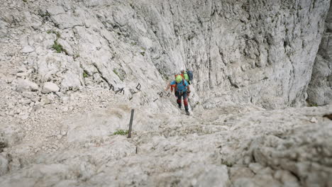 Wanderer-Klettern-Auf-Felsen-Auf-Einen-Berg,-Die-Kamera-Bewegt-Sich-Von-Ihnen-Weg