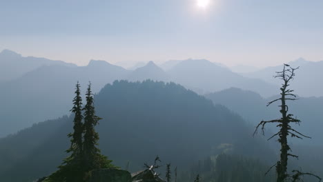 Luftaufnahmen,-Die-Im-Morgendlichen-Dunst-In-Den-Cascade-Mountains-In-Washington-über-Den-Gipfel-Eines-Berges-Fliegen