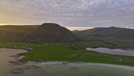 Stave-Norway-Aerial-v9-spectacular-golden-sunset-view-drone-flyover-coastal-village-capturing-mountainscape-with-sun-glowing-and-slowly-setting-below-the-mountain---Shot-with-Mavic-3-Cine---June-2022