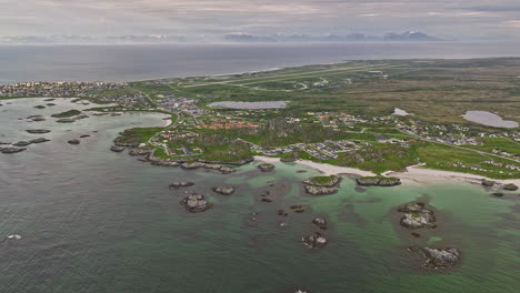 Andenes-Norway-Aerial-v7-breathtaking-panning-birds-eye-view-overlooking-at-small-coastal-village,-pristine-andfjorden-and-wilderness-mountainscape---Shot-with-Mavic-3-Cine---June-2022