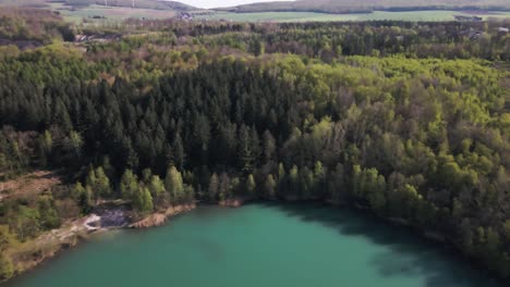 Drohne-Fliegt-über-Dem-Malerischen-Blauen-See-Inmitten-Des-Bergwaldes