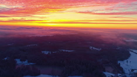 Drohne,-Die-In-Einem-Atemberaubenden-Sonnenuntergang-Auf-Ein-Wolkenmeer-über-Einer-Verschneiten-Landschaft-Zufliegt