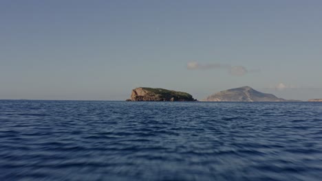 Antena---Volando-Bajo-Sobre-El-Mar-Hacia-Una-Pequeña-Isla-En-Grecia