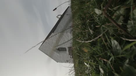 VERTICAL-12th-Century-St-Cwyfan-Cribinauon-island-Church-on-the-isle-of-Anglesey-grassy-hillside