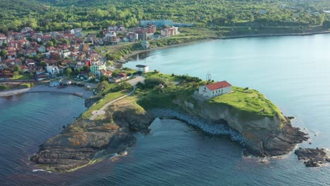 Aerial-view-of-beautiful-cape-in-Tsarevo-with-small-church-standing-on-top-of-the-rocky-hill