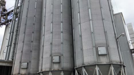 Establishing-shot-of-multiple-large-metal-feed-silos