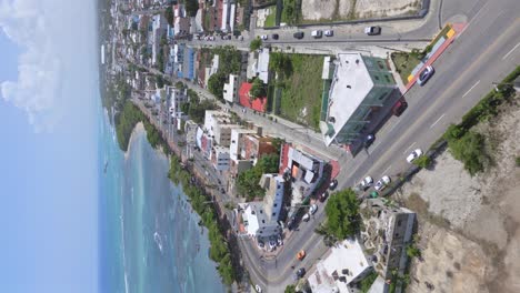 Vertical-Shot-Of-Cars-Driving-On-The-Coastal-Road-Of-Puerto-Plata-City-In-The-Dominican-Republic