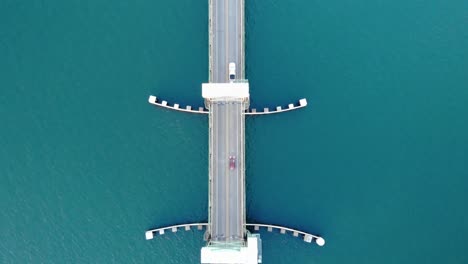 Antena-De-Arriba-Hacia-Abajo-Coche-Eléctrico-Autónomo-Cruce-De-Autopista-Elevación-Vertical-Puente-De-La-Bahía-De-New-Young-Sobre-El-Océano