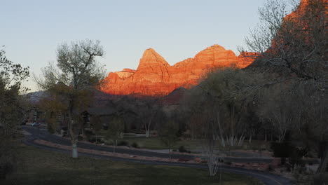 Drone-flying-forwards-revealing-Zion-National-Park-canyons-illuminated-by-sun-setting