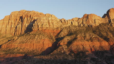 Reddish-sandstone-vertical-canyon-walls-in-Springdale,-Zion-National-Park-wilderness-at-sunset