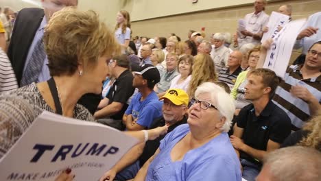 El-Candidato-Presidencial-Republicano-Estadounidense-Donald-Trump-Voluntario-Entrega-Señales-De-Triunfo-Antes-De-Un-Evento-De-Campaña-Del-Caucus-De-Iowa