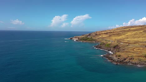 Excellent-Aerial-Shot-Of-Cars-Driving-Along-The-Coastal-Honoapi'Ilani-Highway-Past-A-Lighthouse-In-Maui,-Hawaii