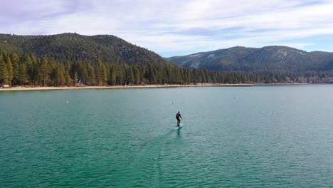 Un-Hombre-Monta-Una-Tabla-De-Surf-Electrónica-Efoil-Hoverboard-De-Hidroala-A-Través-Del-Lago-Tahoe,-California-En-Una-Demostración-De-Deporte-De-Lámina-De-Hidroala-Extrema