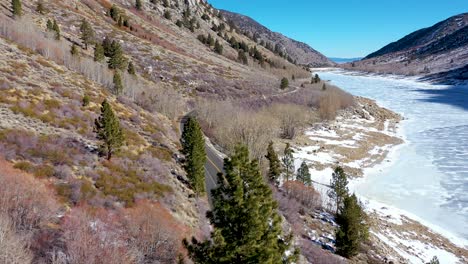 Aerial-Of-A-4X4-Jeep-Vehicle-Driving-On-A-Remote-Moutain-Road-In-Winter-Near-Yosemite-Or-Mammoth-California