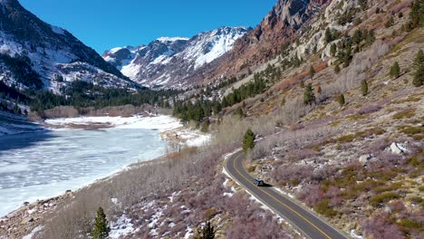 Antena-De-Un-Vehículo-Todoterreno-4x4-Que-Conduce-Por-Una-Carretera-De-Montaña-Remota-En-Invierno-Cerca-De-Yosemite-O-Mammoth-California