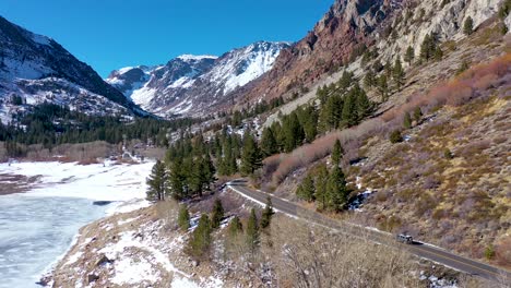 Antenne-Eines-4x4-Jeep-Fahrzeugs,-Das-Im-Winter-Auf-Einer-Abgelegenen-Bergstraße-In-Der-Nähe-Von-Yosemite-Oder-Mammut-In-Kalifornien-Fährt