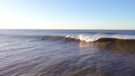 Aerial-Of-Surfer-Surfing-Riding-Large-Ocean-Waves-With-Surf-Breaking-Off-The-Coast-Of-Ventura,-California