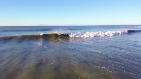 Aerial-Of-Surfer-Surfing-Riding-Large-Ocean-Waves-With-Surf-Breaking-Off-The-Coast-Of-Ventura,-California