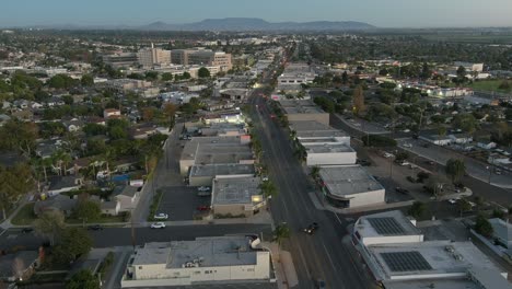 Buena-Antena-Sobre-La-Ciudad-Costera-Genérica-De-Los-Suburbios-De-California-Ciudad-De-Ventura-Al-Atardecer-O-De-Noche-Con-Edificios-Suburbanos-Y-Tráfico