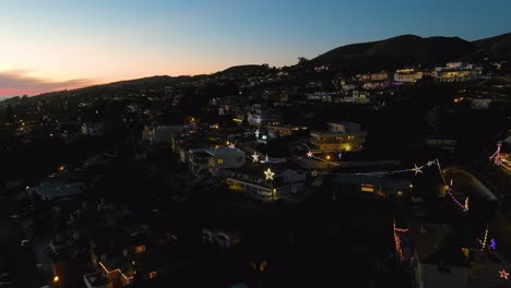 Antena-Sobre-Las-Laderas-Del-Sur-De-California-Ventura-Los-Angeles-En-La-Noche-Al-Atardecer-Con-Casas-Decoradas-Con-Luces-De-Navidad-Y-Estrellas