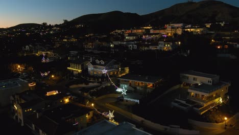 Antena-Sobre-Las-Laderas-Del-Sur-De-California-Ventura-Los-Angeles-En-La-Noche-Al-Atardecer-Con-Casas-Decoradas-Con-Luces-De-Navidad-Y-Estrellas