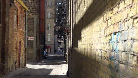 Einspielung-Einer-Leeren-Gasse-In-Einer-Innenstadt,-Durch-Die-Ein-Obdachloser-Läuft