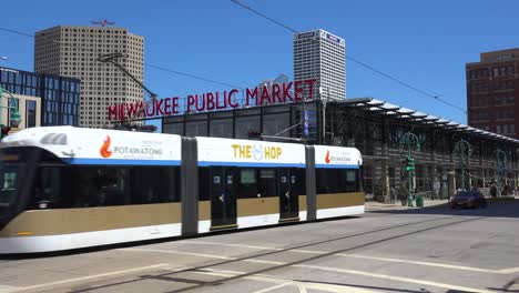 Electric-Trams-Transit-Trains-Move-Down-A-Street-In-Downtown-Milwaukee,-Wisconsin-Near-The-Milwaukee-Public-Market