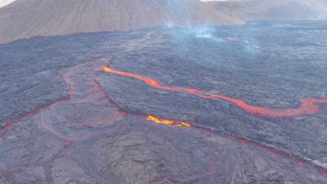 Hermosa-Toma-Aérea-Abstracta-De-Ríos-De-Lava-Que-Fluyen-Cerca-De-La-Erupción-Explosiva-Volcánica-Del-Volcán-Fagradalsfjall-En-Islandia