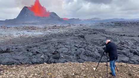 Ein-Mann-Filmt-Einen-Vulkanausbruch-Aus-Nächster-Nähe-Mit-Einer-Kamera-Und-Einem-Stativ-Im-Fagradalsfjall-Eruption-Island