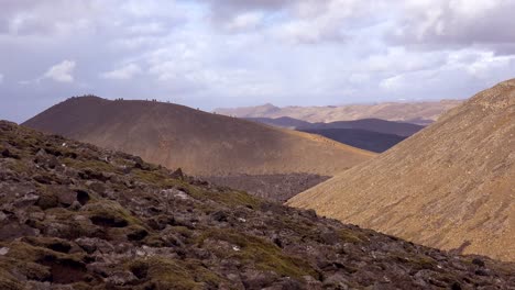 Touristen-Wandern-über-Ferne-Berge,-Um-Einen-Blick-Auf-Den-Isländischen-Vulkanausbruch-Fagradalsfjall-Zu-Erhaschen