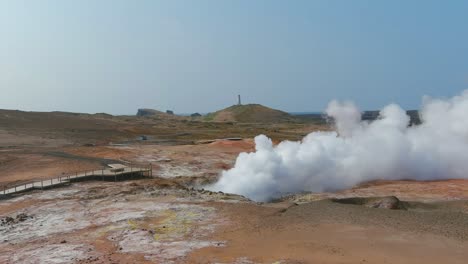 Luftfahrt-Vorbei-An-Dampfend-Heißen-Fumerolen-In-Einem-Geothermischen-Aera-Zeigt-Den-Hübschen-Reykjanes-Leuchtturm-In-Der-Ferne