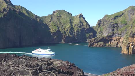 Die-Fähre-Der-Westmännerinseln-Verlässt-Den-Hafen-Von-Vestmannaeyjar-Und-Passiert-Hoch-Aufragende-Inselklippen