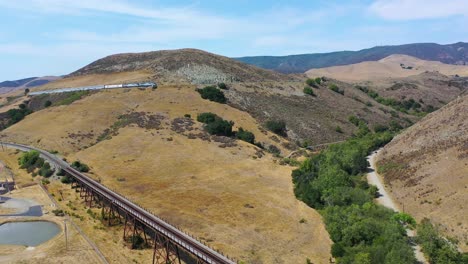 Excelente-Toma-Aérea-Ascendente-Del-Tren-De-Pasajeros-De-Amtrak-Que-Asciende-Por-La-Cuesta-Cerca-De-San-Luis-Obispo,-California