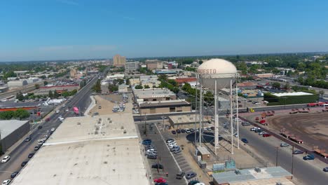 Establishing-Aerial-Of-Merced,-California-Watertank-And-Downtown-Skyline