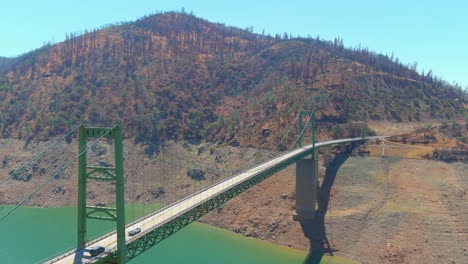 Inquietante-Antena-Sobre-El-Lago-Oroville-De-California-Azotado-Por-La-Sequía-Con-Bajos-Niveles-De-Agua,-Costa-En-Retroceso-Y-Gran-Cruce-De-Puentes