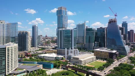 Hermosa-Antena-Ascendente-Sobre-El-Río-Colorado-En-El-Centro-De-Austin,-Texas-Con-Horizonte-Y-Fondo-Del-Edificio-Del-Capitolio