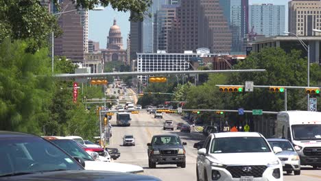 Ver-El-Tráfico-Por-La-Calle-Del-Congreso-En-Austin,-Texas-Con-El-Edificio-Del-Capitolio-En-La-Distancia